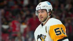 the hockey player is looking to his left with an intense look on his face as he stands in front of fans