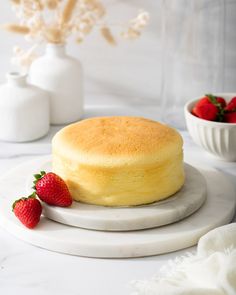 a cake on a plate with strawberries next to it