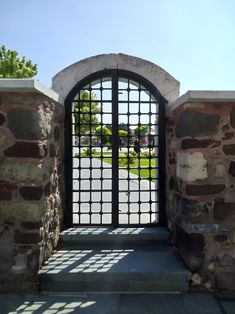 an open gate with the sun shining through it