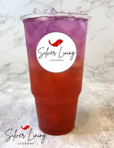 a purple drink in a plastic cup with ice on the rim, sitting on a marble surface