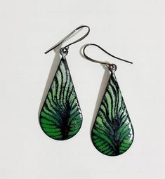 These earrings are made by torch firing enamel (powdered glass) onto copper. Ive drawn some veining into the shades of green enamel, allowing all the black enamel to show thru. They are shown on a gunmetal ear wire which is nickel and lead free. This copper shape is about 2 inches long and are light and comfy to wear. Truly one of a kind! Dress them up or wear them casually - they look cool either way! Each order is custom made. Enameling Jewelry, Butterfly Wing Earrings, Tear Drop Earrings, Painted Jewelry, Hippie Earrings, Enameled Copper, Green Jewelry, Nature Inspired Jewelry, Colorful Jewelry