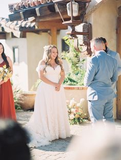 a woman in a wedding dress standing next to a man