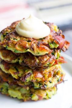 a stack of zucchini fritters with a dollop of cream on top