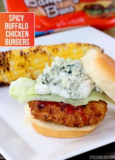 chicken burgers with blue cheese and corn on the cob are served on a white plate