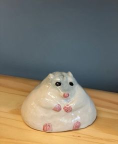 a ceramic bear sitting on top of a wooden table