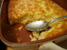 a close up of a spoon in a casserole dish with food on it