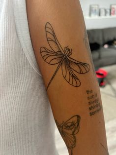 a woman's arm with a dragonfly tattoo on the left side of her arm