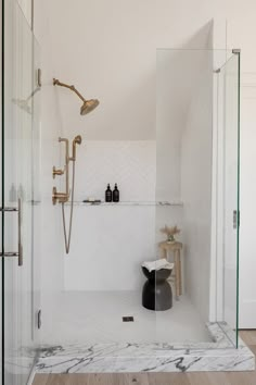 a bathroom with marble flooring and white walls, along with a walk in shower