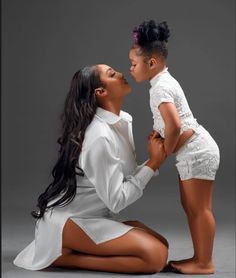 a woman kneeling down next to a small child