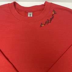 a red t - shirt with the word smile embroidered on it