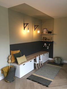 a room that has some chairs and tables in it with lights on the wall above them