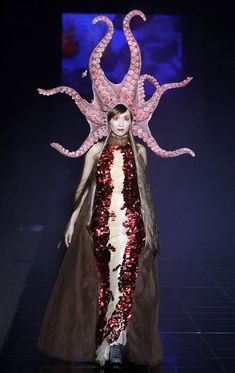 a woman with an octopus costume on the runway