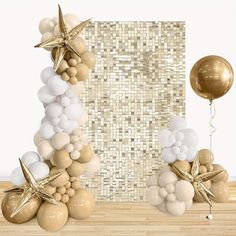 an arrangement of balloons and starfishs in front of a gold sequin backdrop