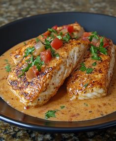 two fish fillets on a plate with sauce and garnishes, ready to be eaten