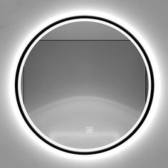 an illuminated circular mirror in the middle of a wall