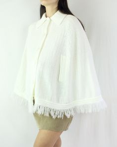 This is such a special piece! This 70s knit poncho cape is so perfect for everyday wear, and can be paired with so many looks and styles. The collar on this piece is lovely, the fringe is fun, and the material (acrylic) is soft and warm. This cape has slits in the front for you to use your arms. This is a button up piece as well, and is in excellent condition for it's age, and for being white! There are no flaws to note. ☼ Brand - Flair Fashions ☼ Material - 100% Acrylic ☼ Color - White ☼ Size - Poncho Jacket, Knitted Cape, Knit Poncho, Ladies Poncho, Jacket Cardigan, Poncho Cape, Fashion Materials, Knitted Poncho, Lightweight Knit