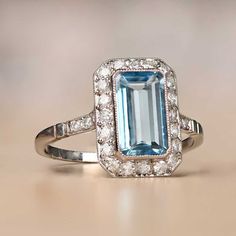 Our skilled jewelry has handcrafted a magnificent platinum March birth stone ring featuring a stunning emerald-cut aquamarine weighing 1.55 carats as its centerpiece. The gemstone's deep saturation makes it lively, accentuated by the sparking row of single-cut diamonds surrounding it, weighing approximately 0.40 carats.  The under-gallery of the ring boasts an elegant open-work design that adds to its beauty. This March birth stone ring is a piece of exquisite craftsmanship, available exclusivel Diamond Ring Emerald Cut, Gold Ideas, Estate Diamond Jewelry, Ring Emerald Cut, Sapphire Wedding, Ring Emerald, Vs Diamond, Work Design, Aquamarine Rings