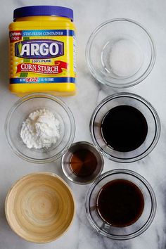 ingredients to make chocolate cake sitting on a marble counter top, including cream and sugar