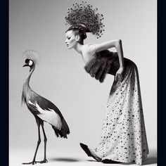 an image of a woman and a bird with feathers on their head, standing next to each other