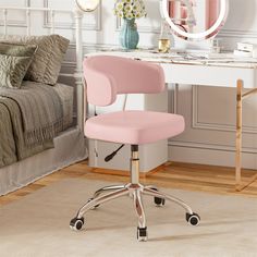 a pink office chair sits in front of a white desk with a mirror on it