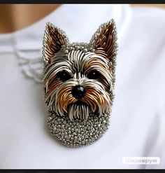 a close up of a dog brooch on a white shirt