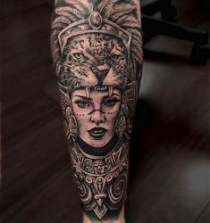 a black and white tattoo with a woman's face on the leg, surrounded by lions