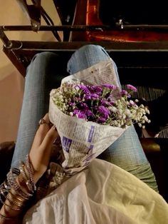 a woman sitting in a chair holding a bouquet of flowers