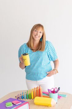 a woman standing next to a table full of school supplies