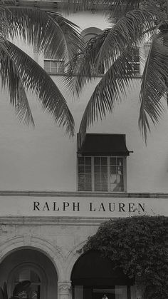 black and white photograph of palm trees in front of a building with the name ralph lauren on it