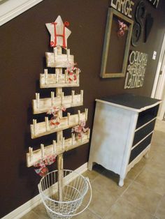 a christmas tree made out of wooden crates on the wall next to a white dresser