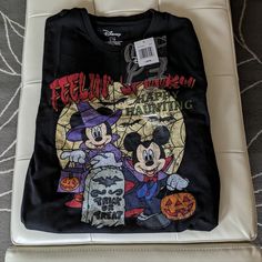 a mickey mouse halloween shirt sitting on top of a bed