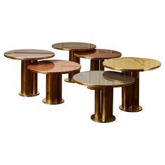 four tables with different shapes and sizes on each one side, all in gold metal