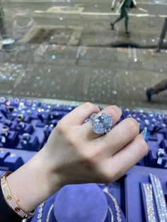 a woman's hand with a ring on it in front of some blue trays