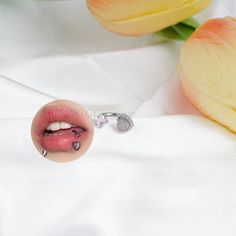 a close up of a person's lips and nose with flowers in the background