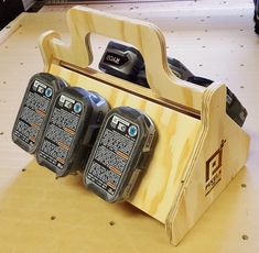 three cell phones are in a wooden holder