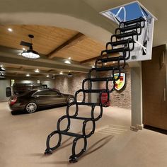 an indoor basketball court with cars parked in the parking lot and a staircase going up to it