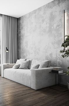 a white couch sitting in front of a window next to a potted plant on top of a wooden floor