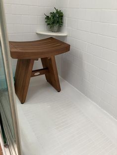 a wooden bench sitting in the middle of a bathroom