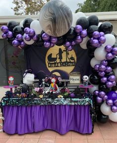 a purple and black table topped with lots of balloons