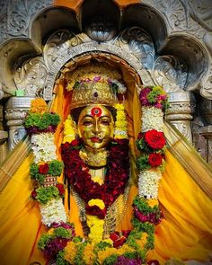 an idol with flowers and garlands around it