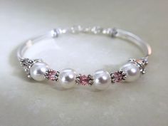 Swarovski crystals and pearls is perfect for your wedding, anniversary, or just because and is for sure to make as statement! It sits so comfortably on your wrist. This bracelet can be purchased with either light rose or crystal ab Swarovski crystals, both are lovely... It's made with four 8mm white swarovski crystal pearls, four 4mm light rose swarovski crystals along with pewter daisy and cone shaped spacers. It closes with a secure lobster claw clasp. Matching necklace: https://www.etsy.com/l Cord Bracelet Diy, Pearl Bracelet Wedding, Crystal Wedding Jewelry, Bridal Party Jewelry, Maid Of Honor Gift, Bachelorette Gift, Bracelet For Her, White Pearl Bracelet, Bridesmaid Pearls