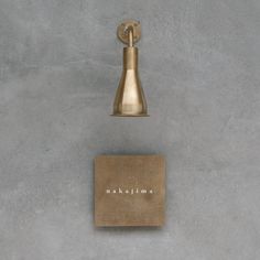 a bell on the side of a wall with a plaque underneath it that says naaklima