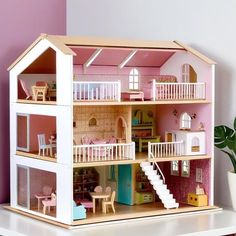 a doll house with pink walls and white stairs