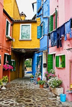 an alley way with colorful buildings and flowers