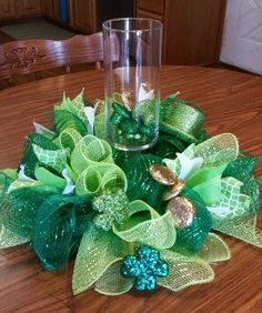 a green centerpiece on top of a wooden table