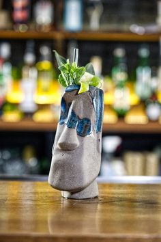 a vase with a plant in it sitting on top of a table next to a bar