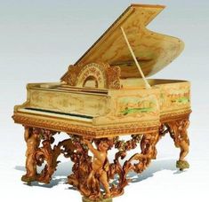 an ornately decorated grand piano sitting on top of a table