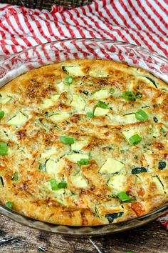 a casserole dish with cheese and vegetables in it on a red and white checkered table cloth