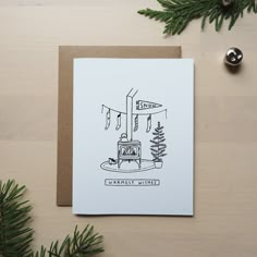 a card with a drawing of a stove and christmas tree on the table next to it