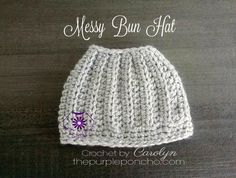 a crocheted hat with a purple flower on the front and white yarn behind it